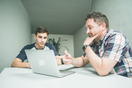 vader en zoon met laptop aan tafel.jpg