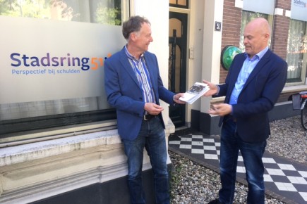 Overhandiging handboek aan Dick van Manen